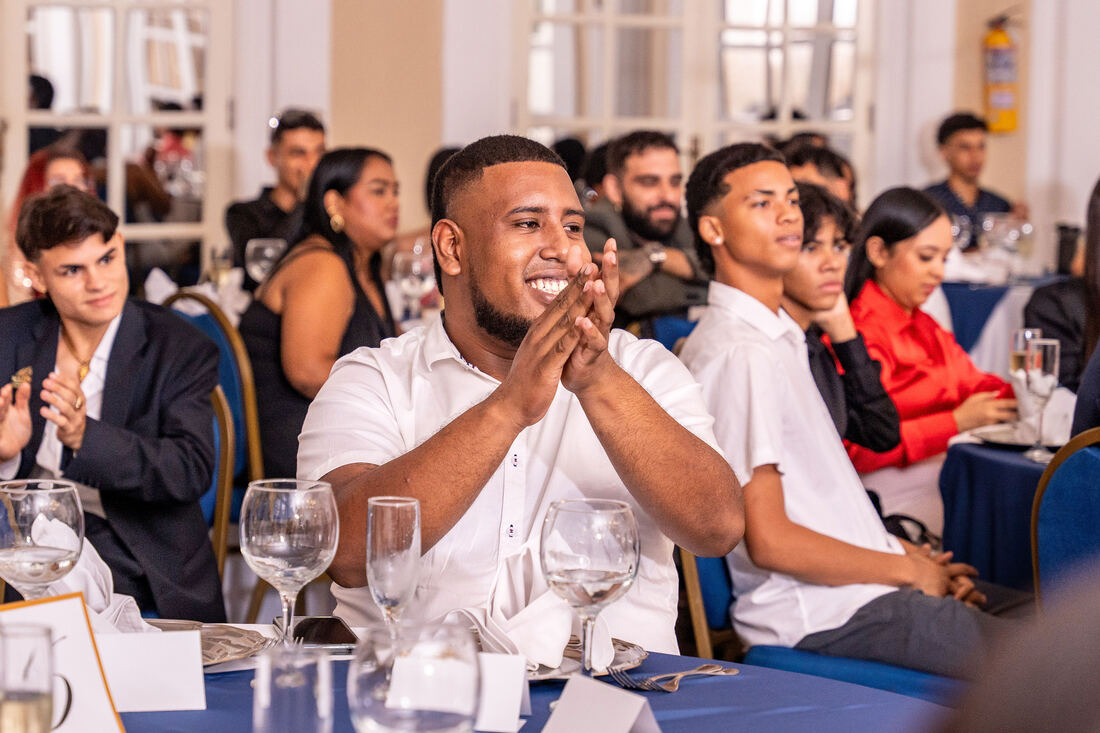 Invitado aplaudiendo sonriente en evento de gala